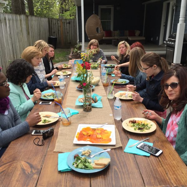 group of women sitting outside eating at a table