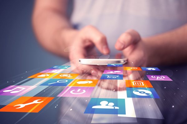 person holding smartphone with colorful application icons coming out
