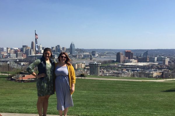 two women smiling with Cincinnati skyline in the background