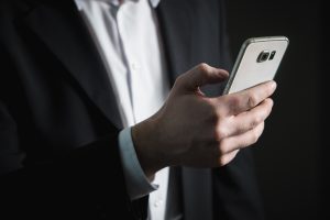 Man in business suit holding cell phone