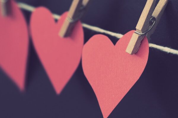 construction paper hearts attached to a string by clothespins