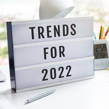 Desk with computer and sign that reads "Trends for 2022"