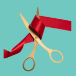 Bronze scissors cutting red ribbon