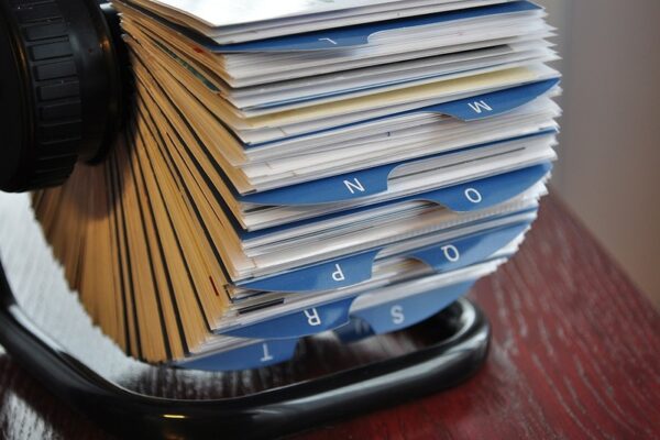 A rolodex with cards for each media contact filed under blue tabs