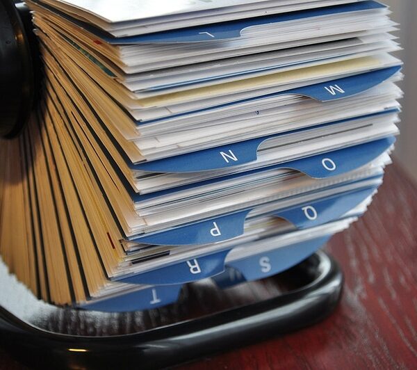 A rolodex with cards for each media contact filed under blue tabs