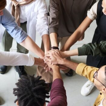 A diverse team putting their hands in a circle
