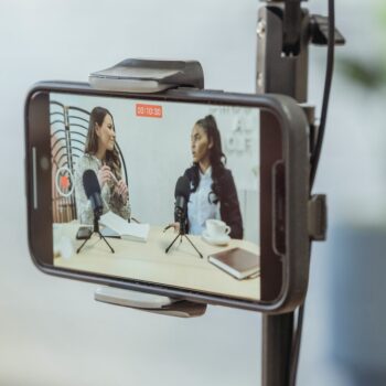 Smartphone on tripod recording vlog of young women