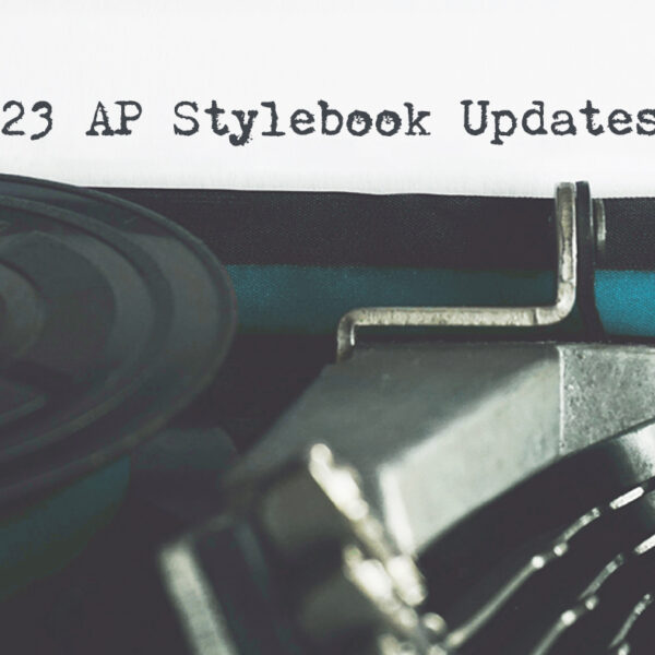 A typewriter with a teal ribbon in front of a sheet of paper with "2023 AP Stylebook Updates" typed on it
